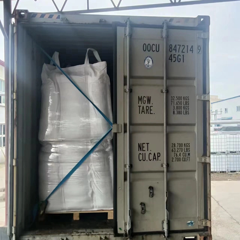 A large bag of white powder is positioned in the back of a truck, indicating construction materials for transport