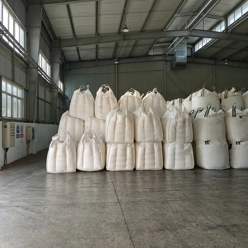 Large bags of white sand stacked in a warehouse, ready for use in construction projects
