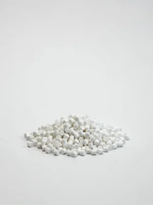 Pequeños gránulos blancos de masterbatch antiniebla AFM-PE2006 sobre un fondo blanco limpio